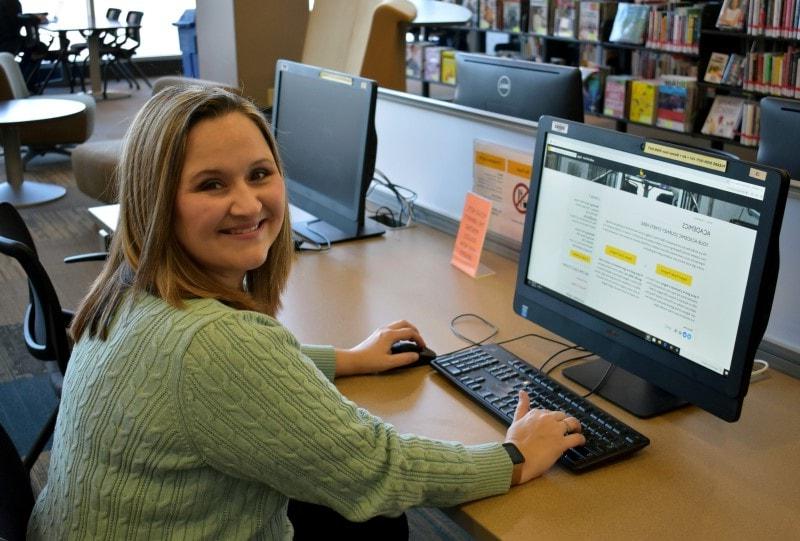 sitting female student using a computer in a library